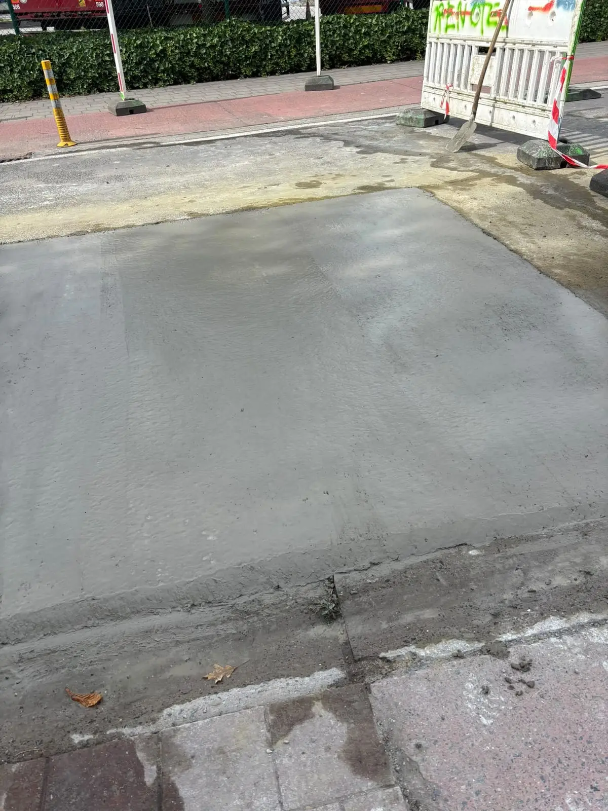 Afgewerkt betonnen voetpad na de rioolaansluiting in Wondelgem